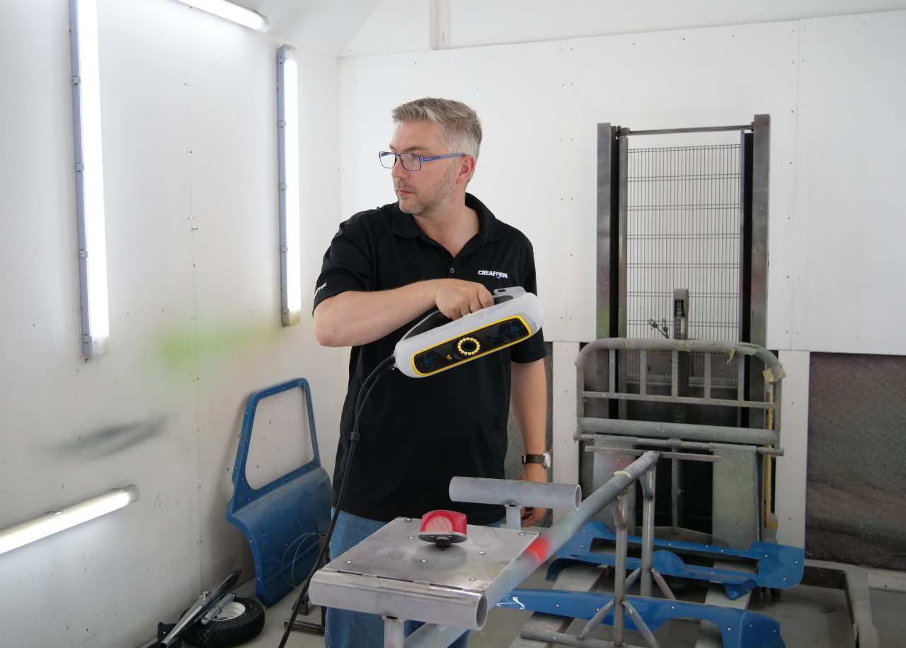 Handheld 3D scanning equipment capturing surface geometry of a Peel P50 body panel.